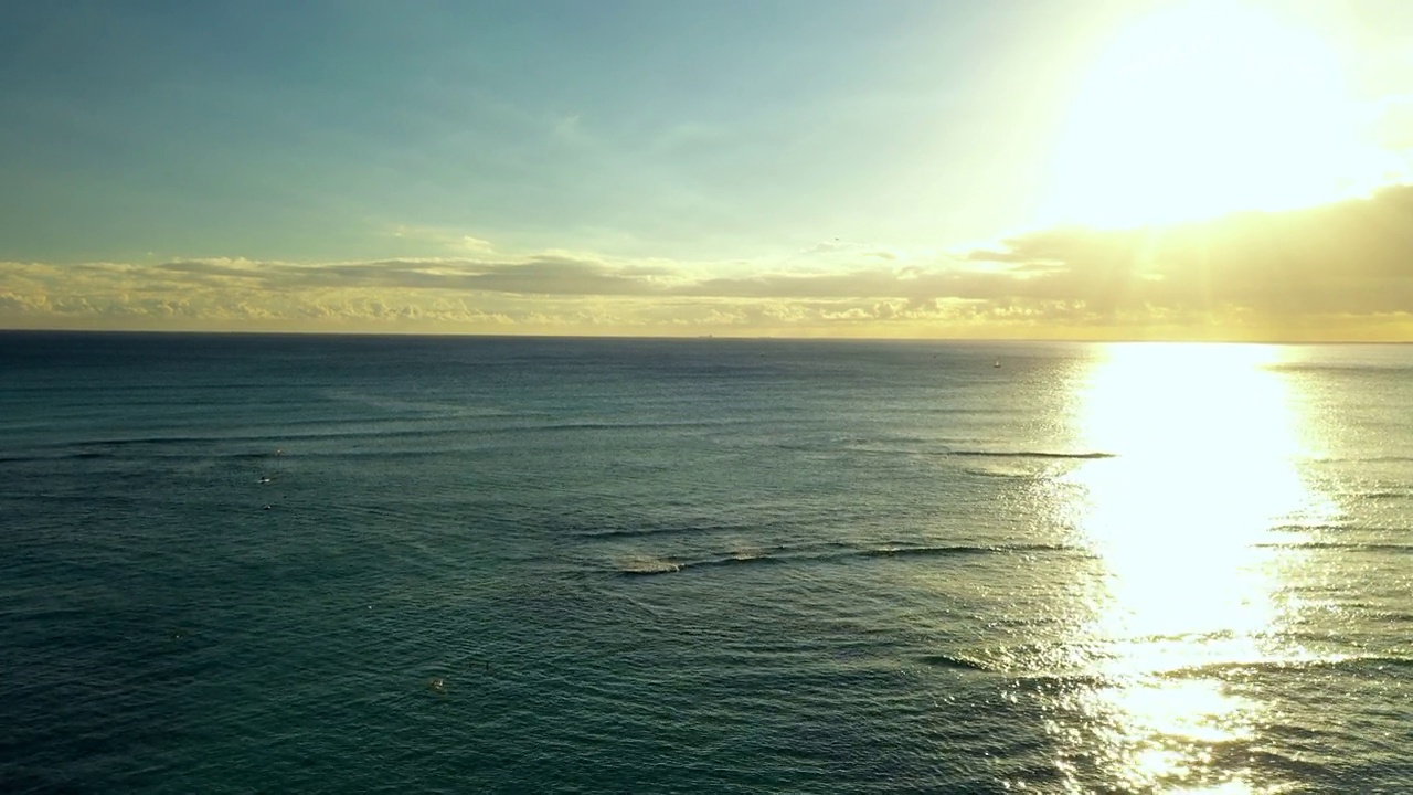 空中向前拍摄的蓝色海与地平线下多云的天空在日落-瓦胡岛，夏威夷视频素材