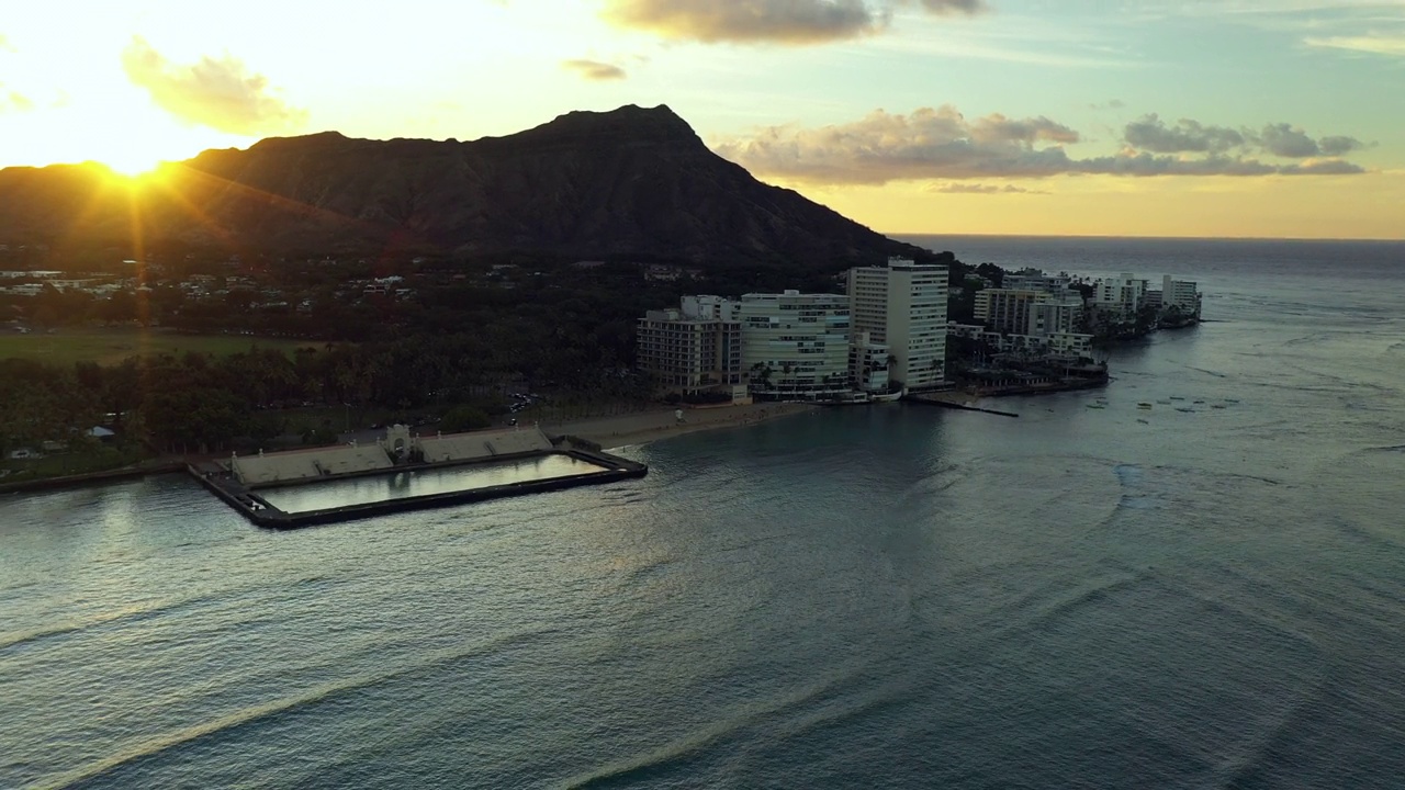 空中拍摄的游泳池与海的酒店建筑在日落期间对山-瓦胡岛，夏威夷视频素材