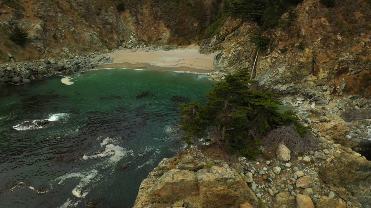 空中平移拍摄瀑布在海滩上流动的山，无人机飞过波浪海-旧金山，加利福尼亚视频素材