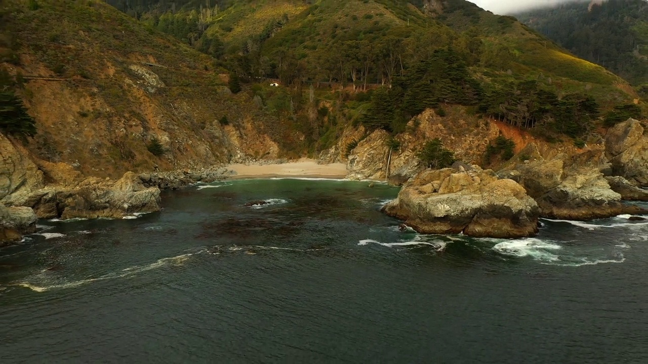 云雾下的山上森林的空中风景，无人机在海滩上向后飞过海洋-旧金山，加利福尼亚视频素材