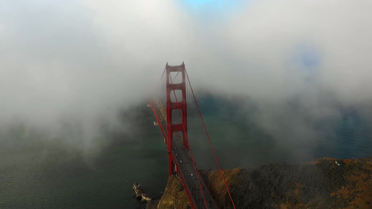 空中平移拍摄的汽车在海上金门大桥上移动在云层下的天空-旧金山，加利福尼亚视频素材