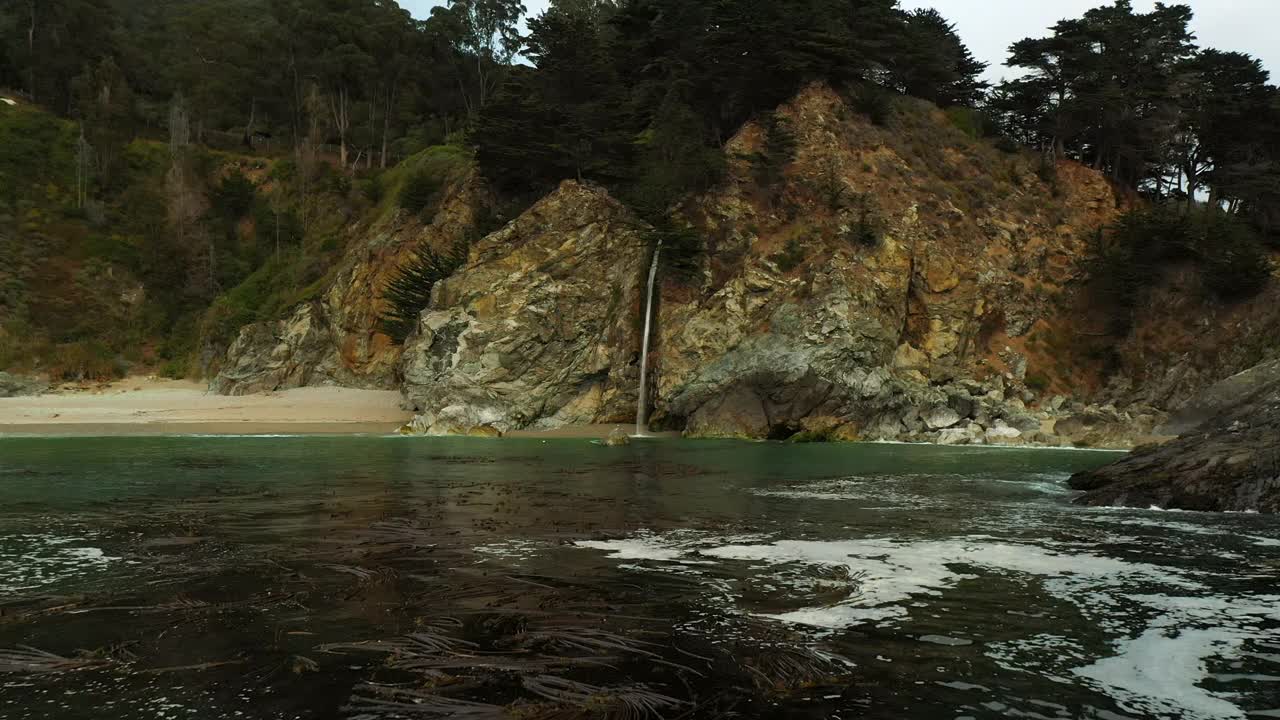 空中拍摄的瀑布在山上流动，反对晴朗的天空，无人机在海上向前飞行-旧金山，加利福尼亚视频素材