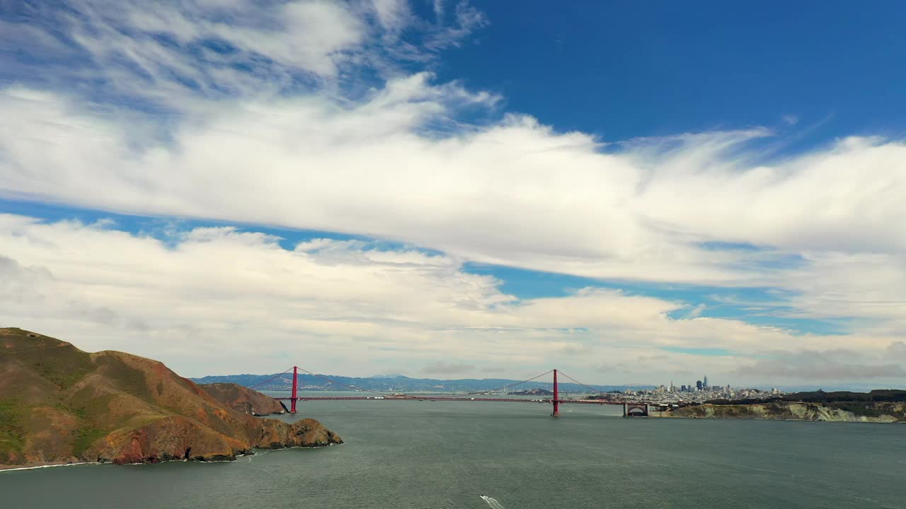 空中拍摄的金门大桥云层下的天空，无人机在海上向前飞行-旧金山，加利福尼亚视频素材