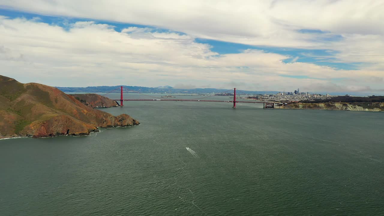 空中向后拍摄的船移动到多云的天空下金门大桥-旧金山，加利福尼亚视频素材