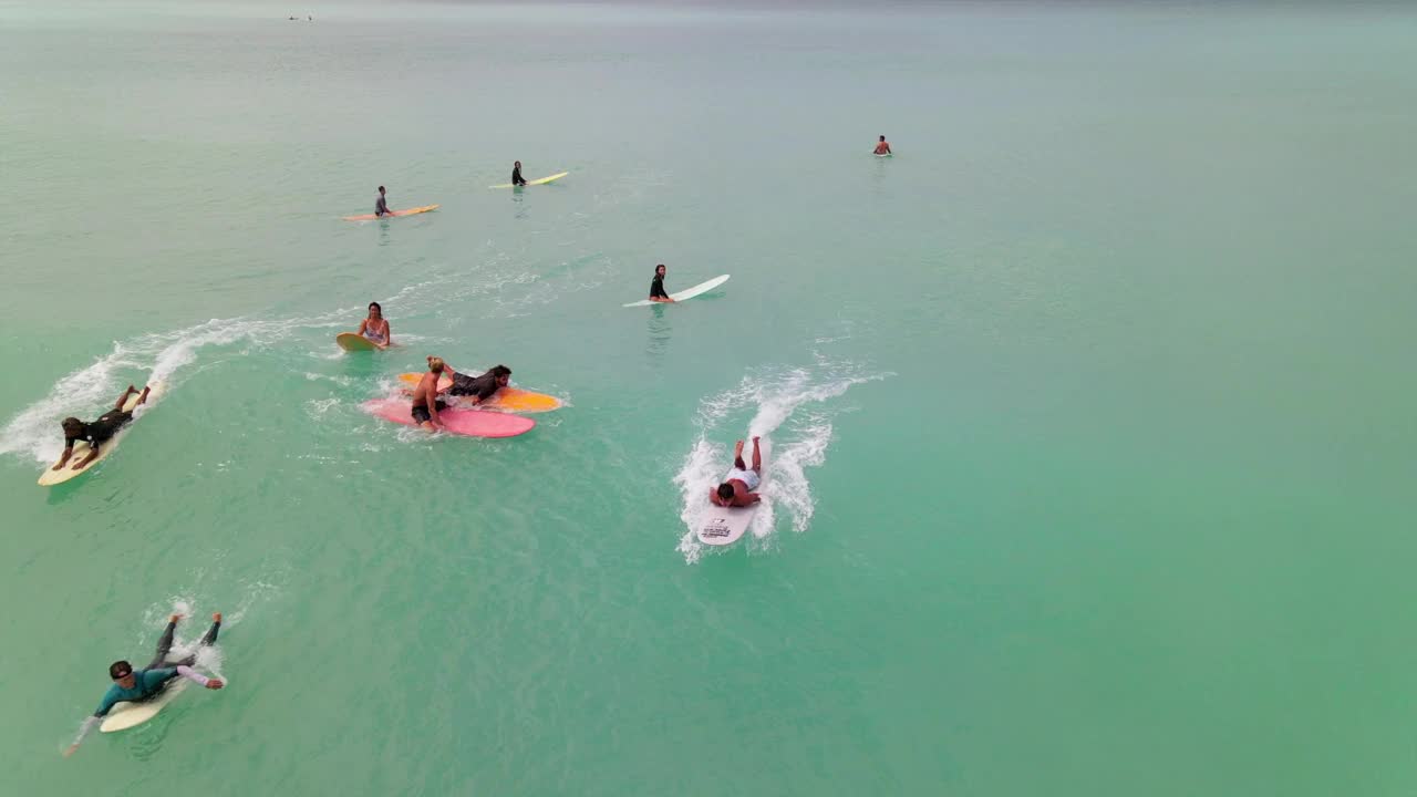 人们在度假时用冲浪板在海上冲浪的空中向后拍摄-夏威夷威基基视频素材