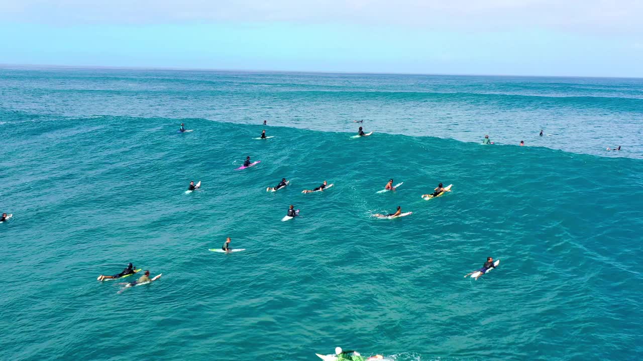 空中向后拍摄的男人和女人在多云的天空下冲浪-夏威夷怀基基视频素材