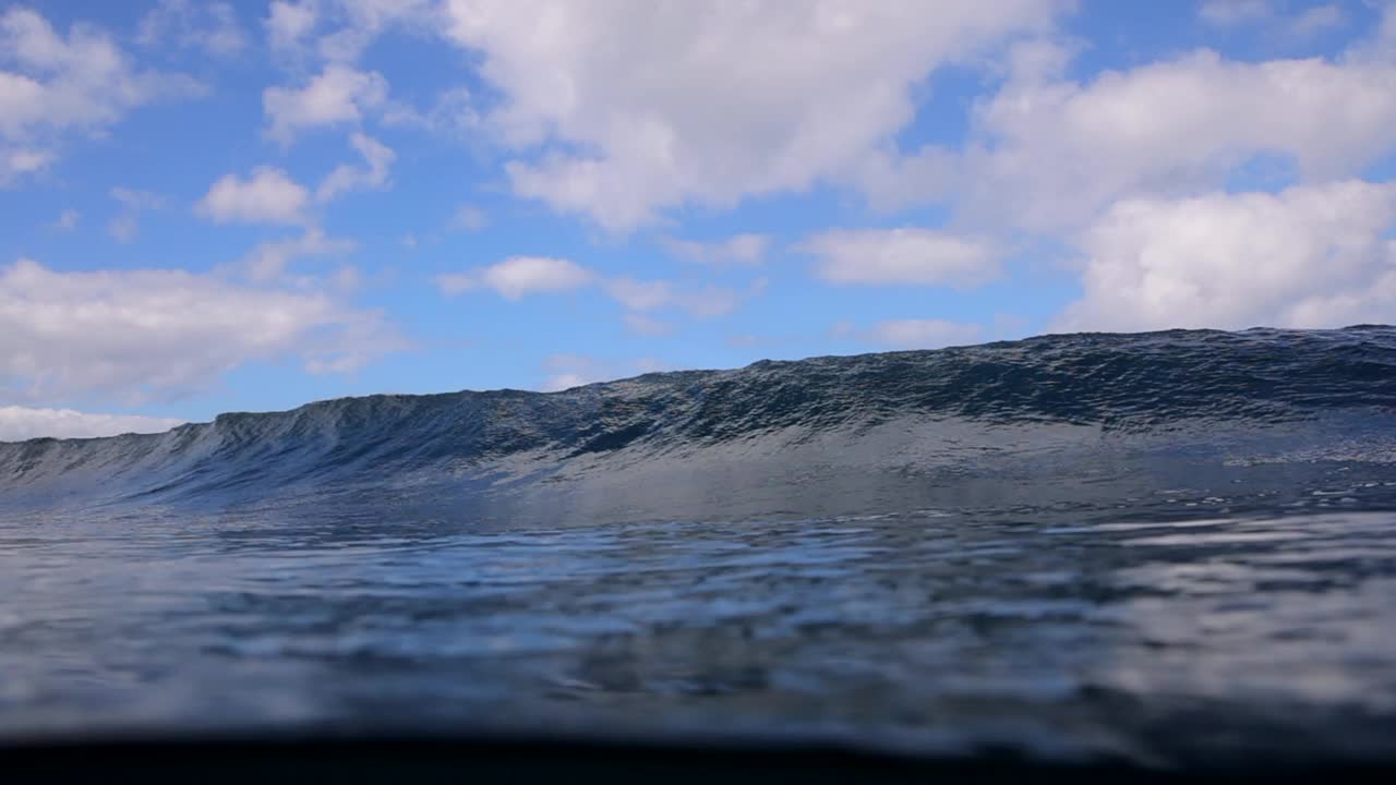 在海滩上，在多云的天空下，慢动作平移海中的高浪的美丽观点-檀香山，夏威夷视频素材