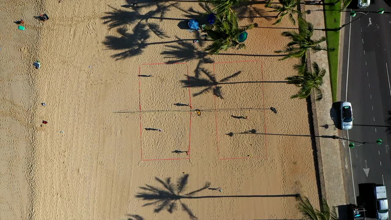 人们在阳光明媚的日子里在海滩上打排球的空中俯拍-夏威夷瓦胡岛视频素材