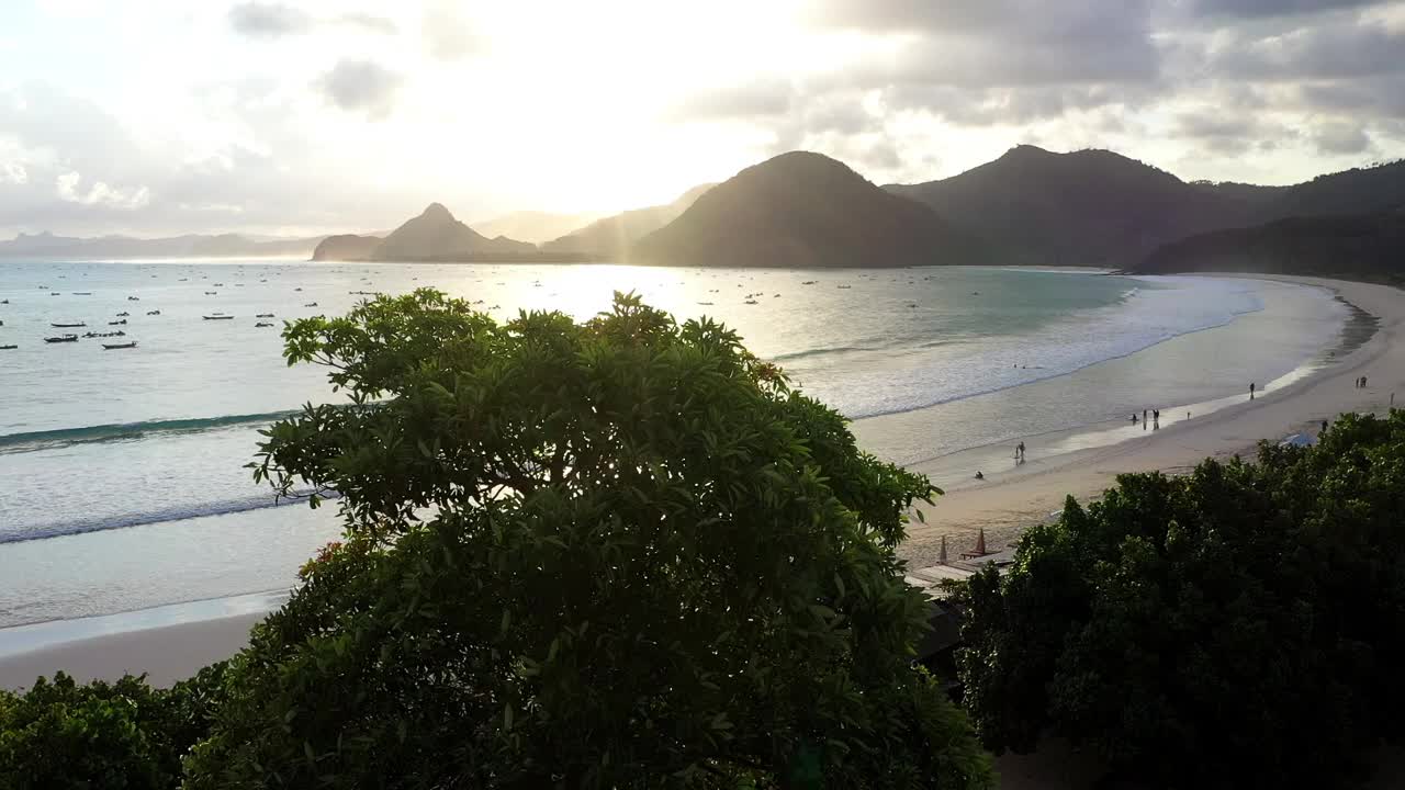 空中拍摄的水牛在日落时走在海边的山-龙目岛，印度尼西亚视频素材