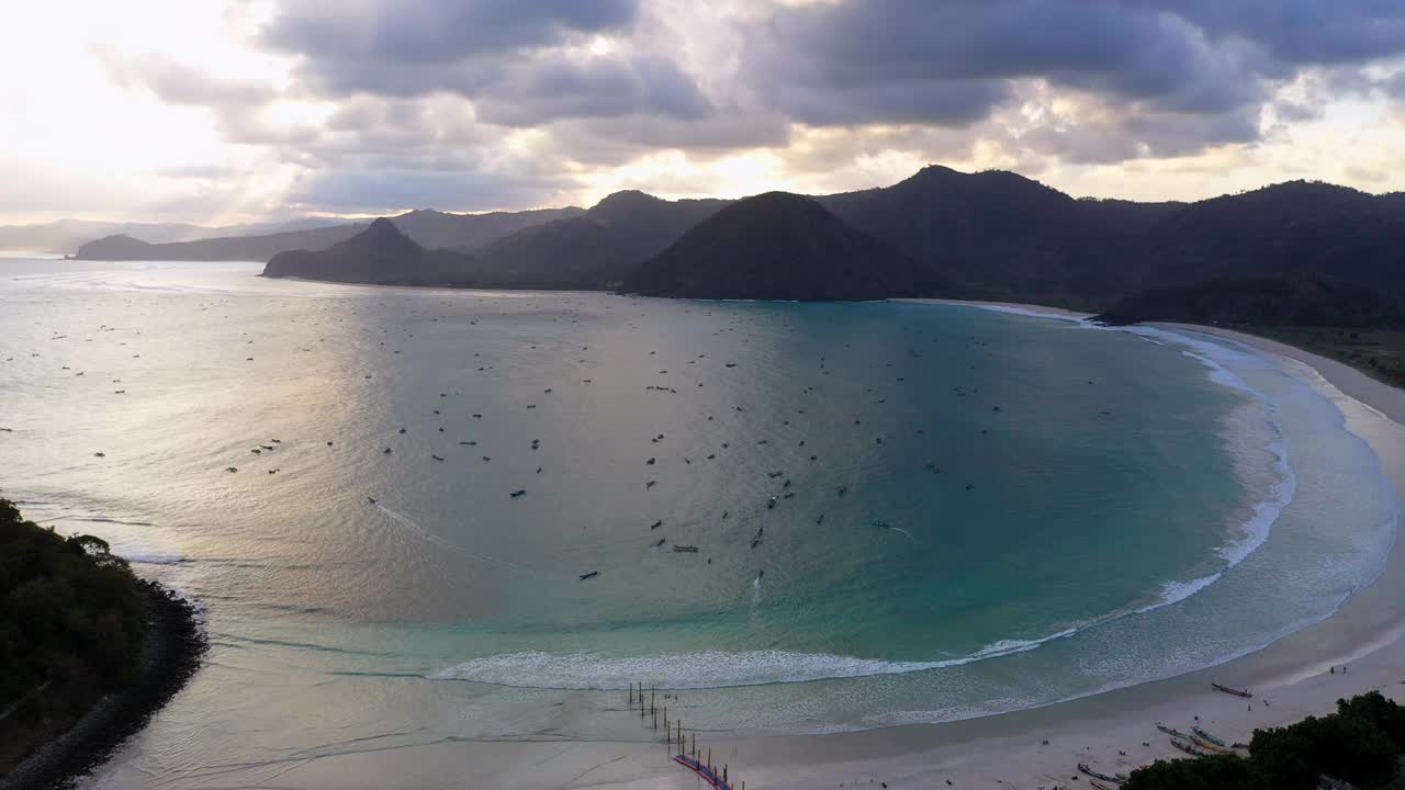 空中向后拍摄的船在海上对山在多云的天空下-龙目岛，印度尼西亚视频素材