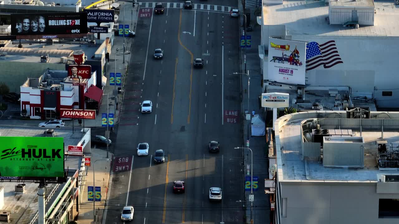 空中倾斜拍摄的汽车在日落期间在城市住宅建筑的道路上移动-加利福尼亚州圣莫尼卡视频素材