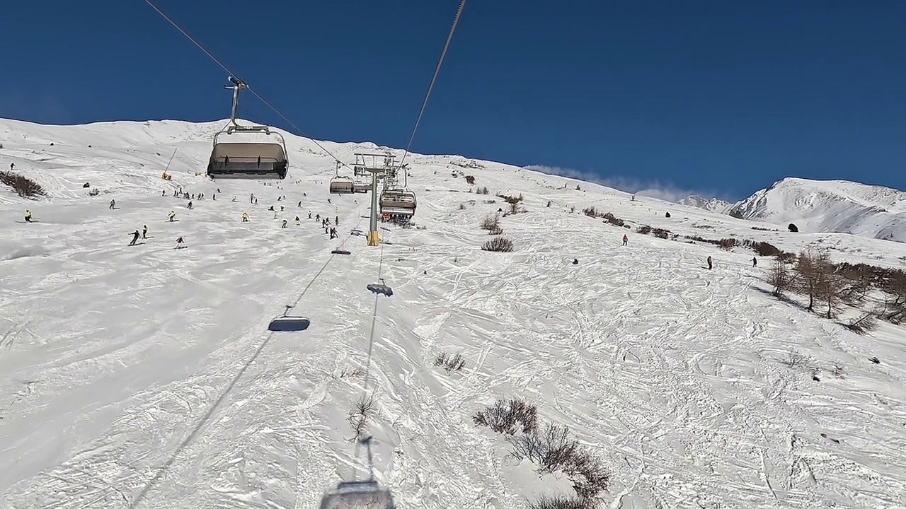 Tonale, Ponte di Legno，意大利。在一个阳光明媚的日子里，滑雪者在缆车上移动到滑雪道的顶部视频素材