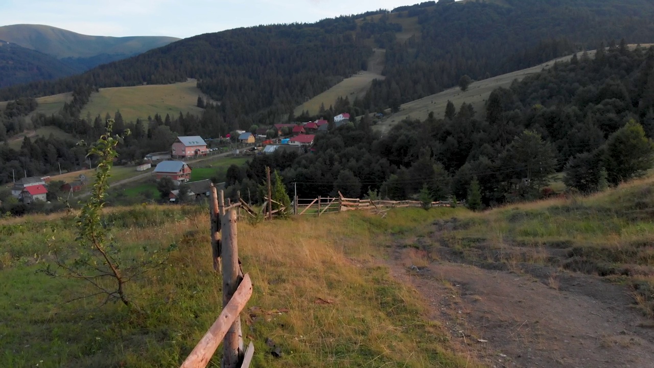 夕阳下的乌克兰山区，一个乡村农场的旧栅栏和一条土路。美丽的乌克兰，喀尔巴阡山脉视频素材