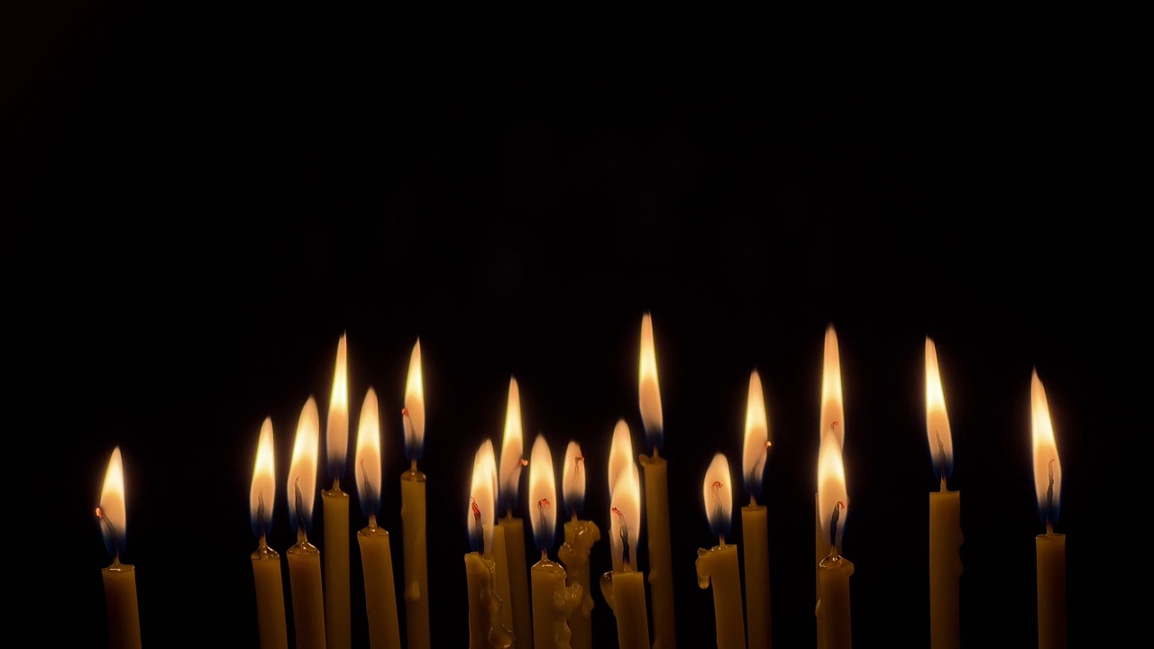 许多蜡薄的蜡烛明亮地燃烧着。宗教的概念。视频素材
