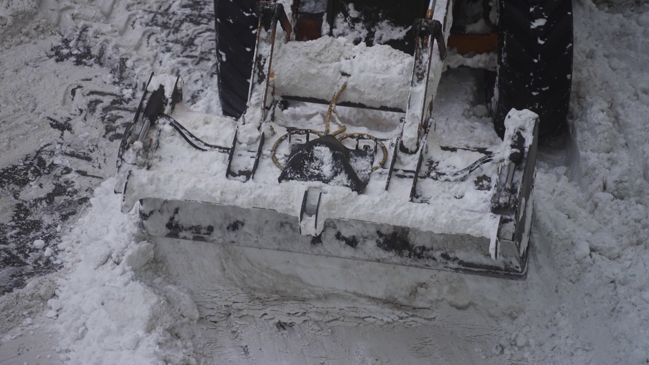 拖拉机在街上铲雪。视频素材