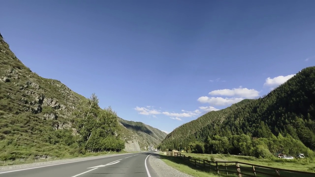 汽车在美丽的风景背景下沿着山路行驶。视频素材