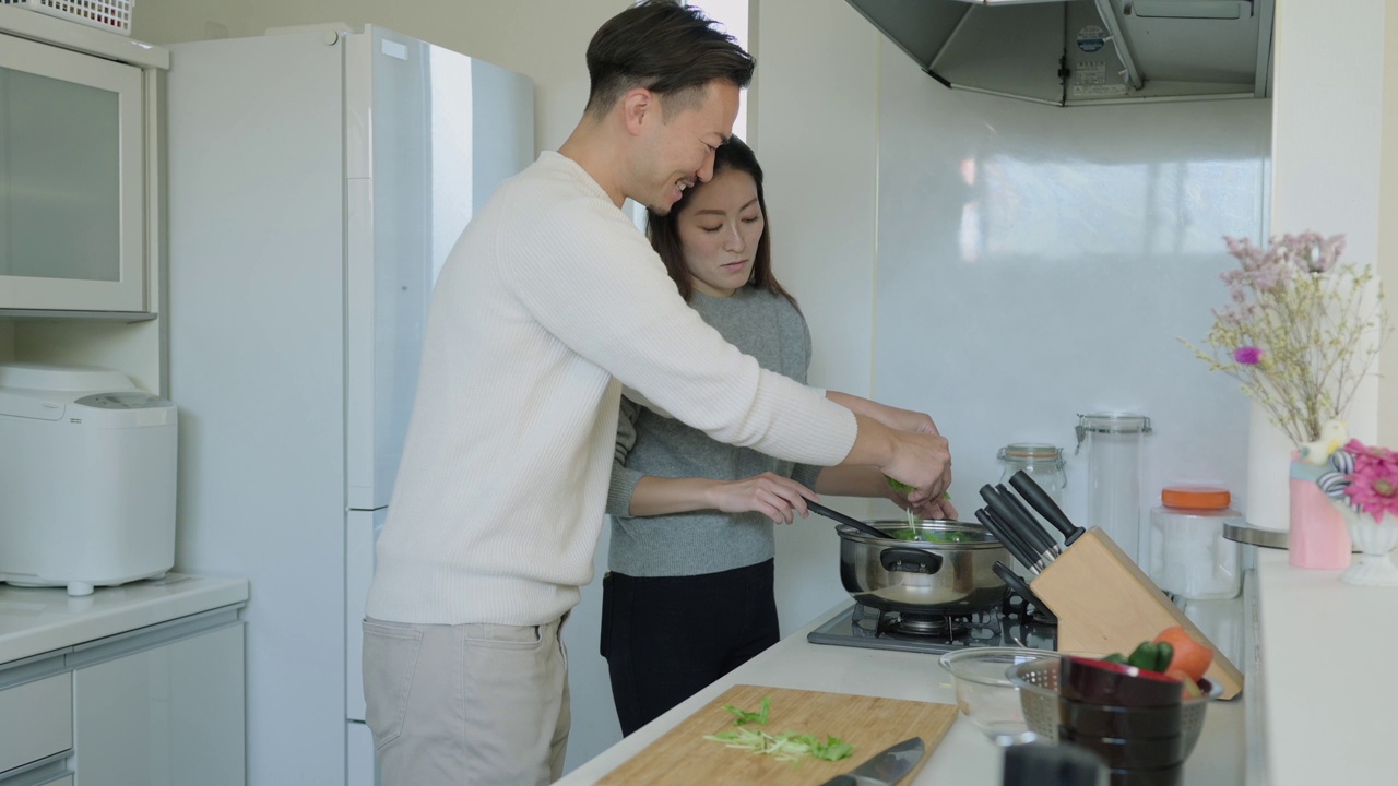 一对亚洲夫妇在厨房一起做饭视频素材