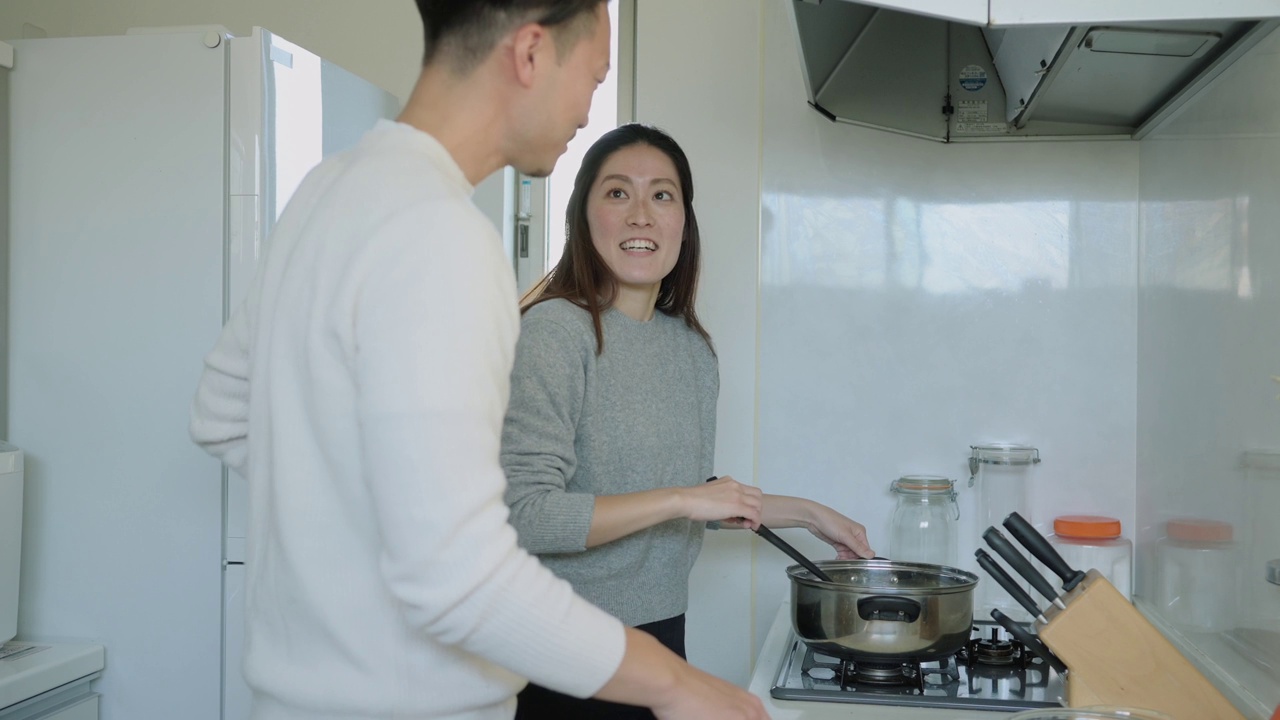 一对亚洲夫妇在厨房一起做饭视频素材