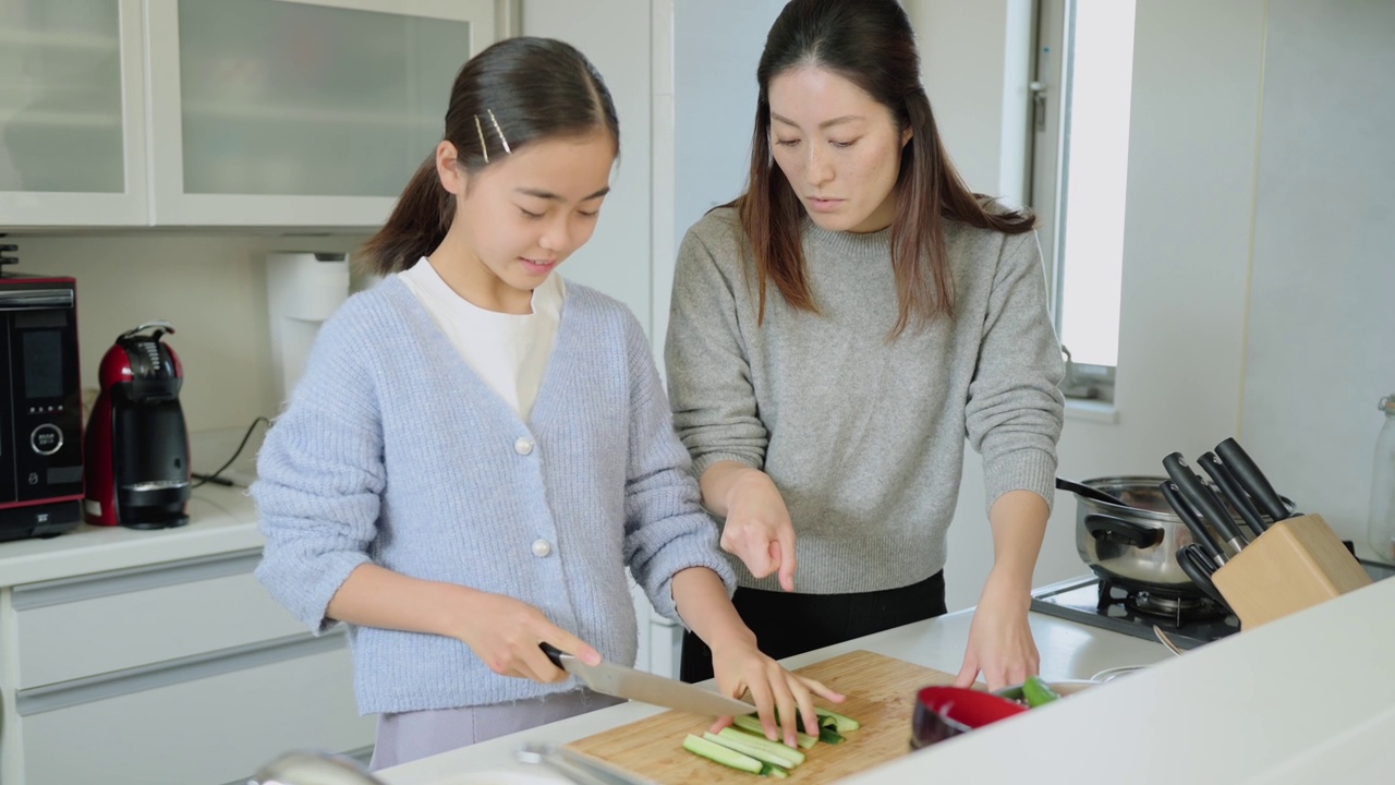 母亲教她十几岁的女儿做饭。视频素材