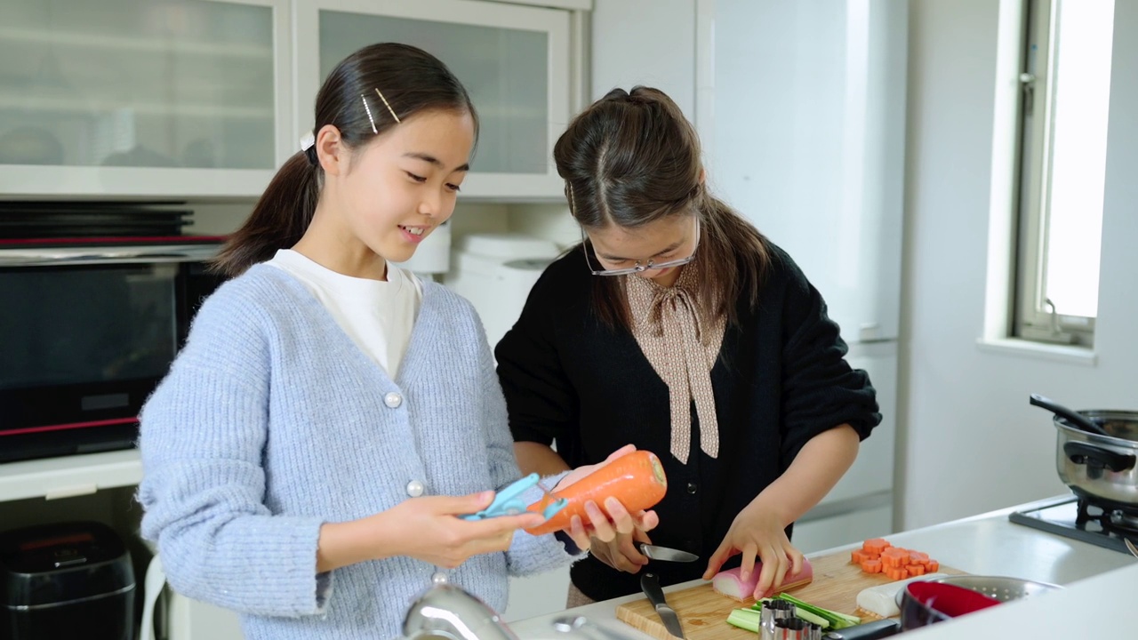 两个十几岁的女孩快乐地在一起做饭。视频素材