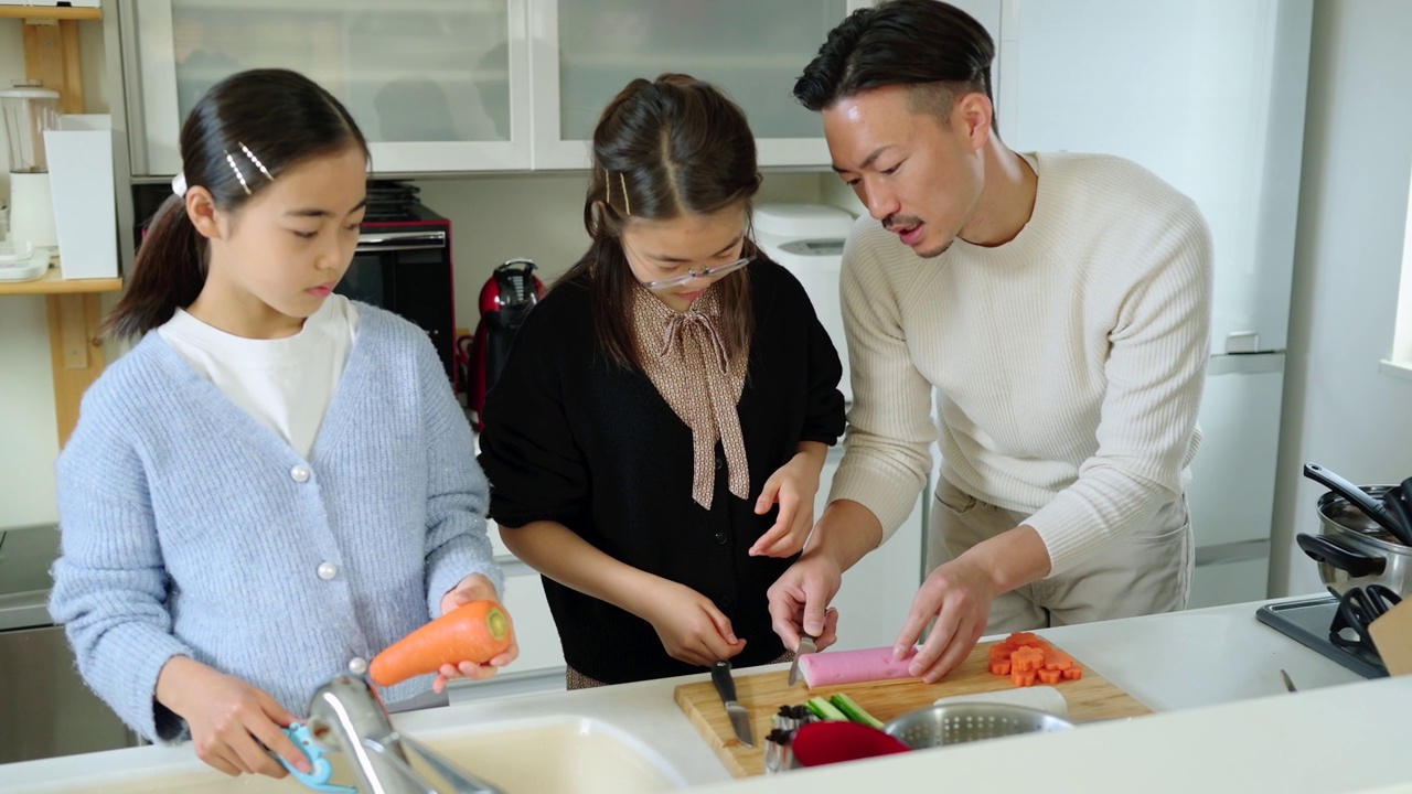 两个女儿在厨房做饭，父亲在帮她们视频素材