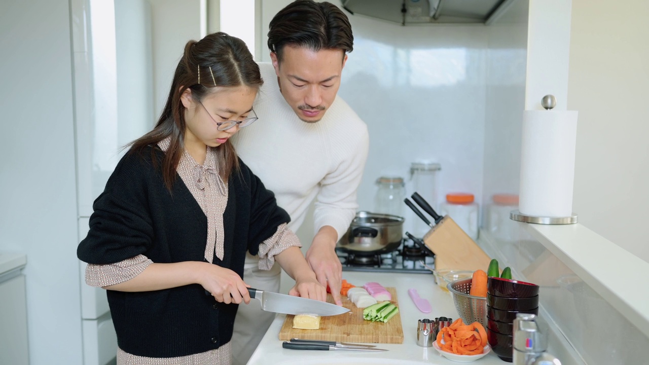 女儿在厨房做饭，父亲在帮她视频素材