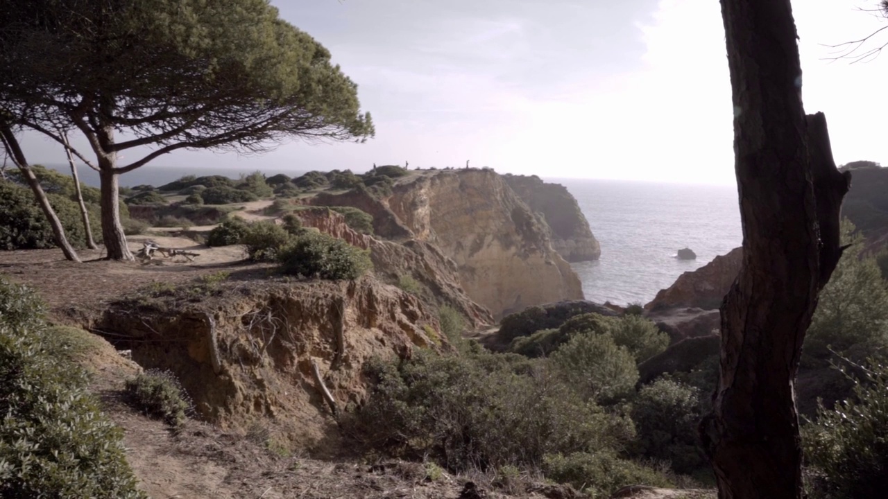 一名男子在葡萄牙Portimao de arens海滩的悬崖上驾驶无人机视频素材