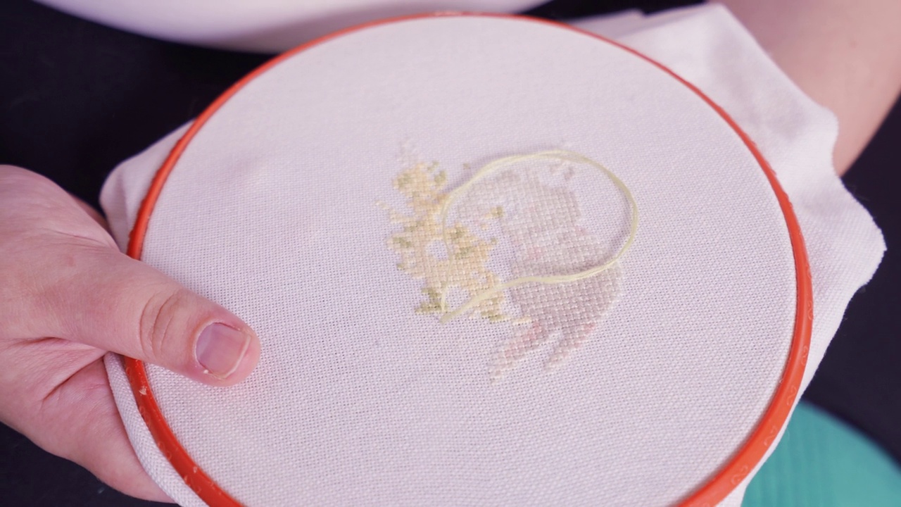 女手用线和针在织物上刺绣图案视频素材
