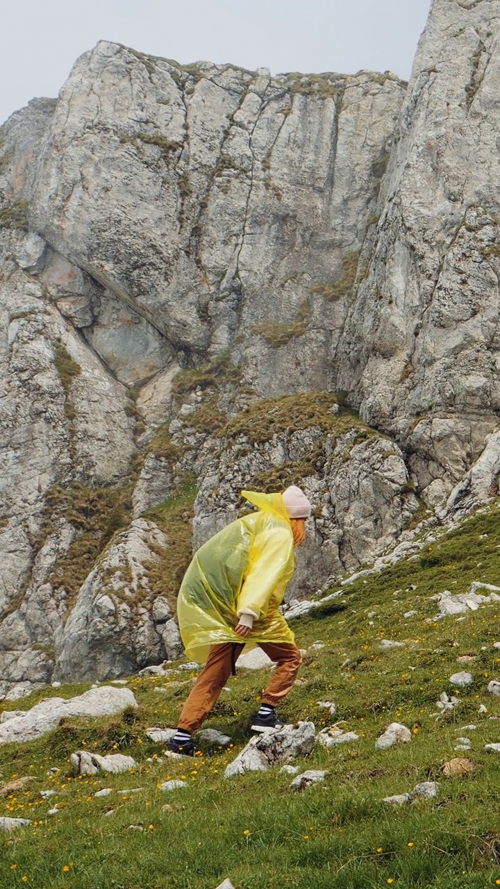 竖屏女子在阴雨蒙蒙的天气里艰难地爬上了山视频素材