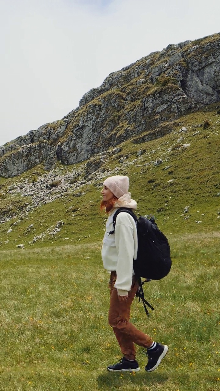 女人走在绿草在山上视频素材