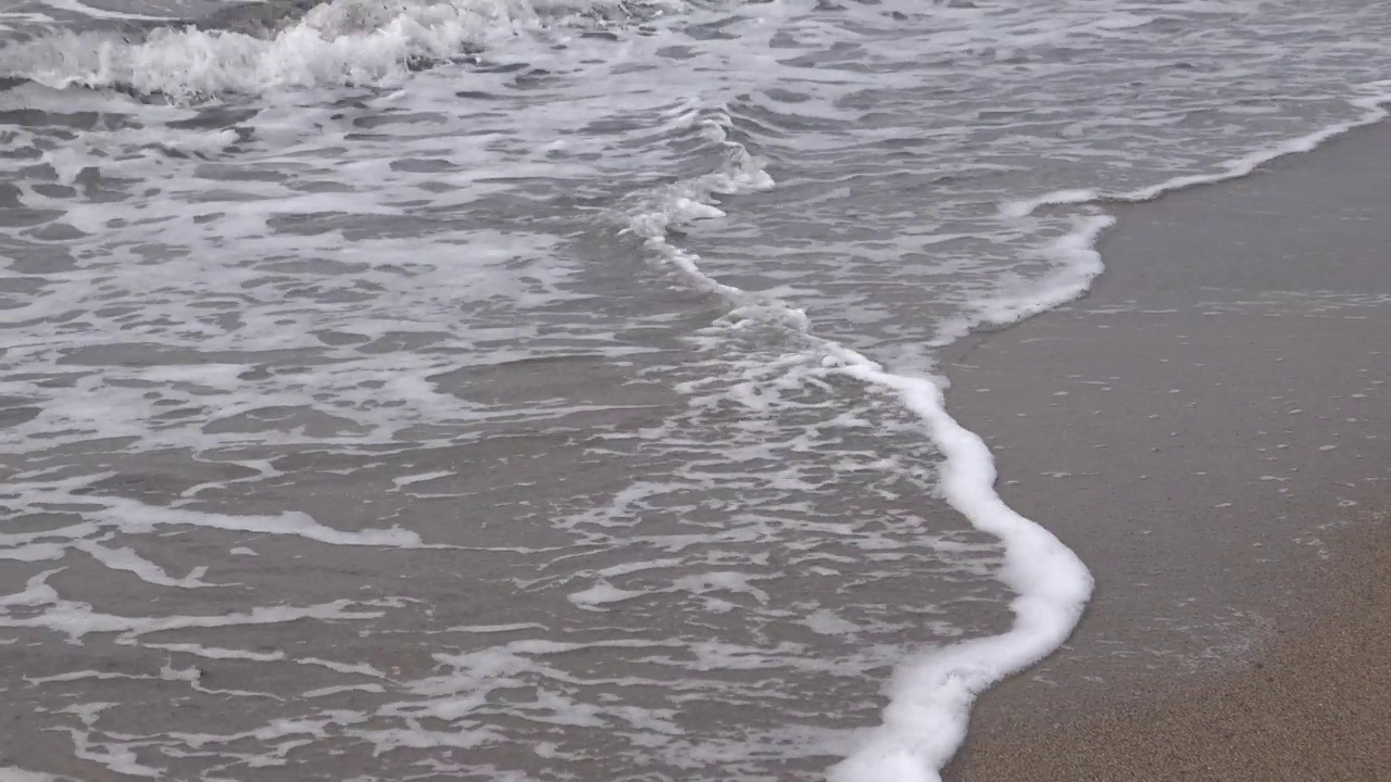 海浪卷起白沙滩的特写镜头视频素材