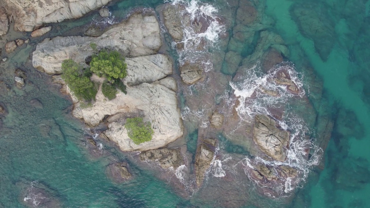 从无人机鸟瞰海岸上的岩石和蓝绿色的水视频下载