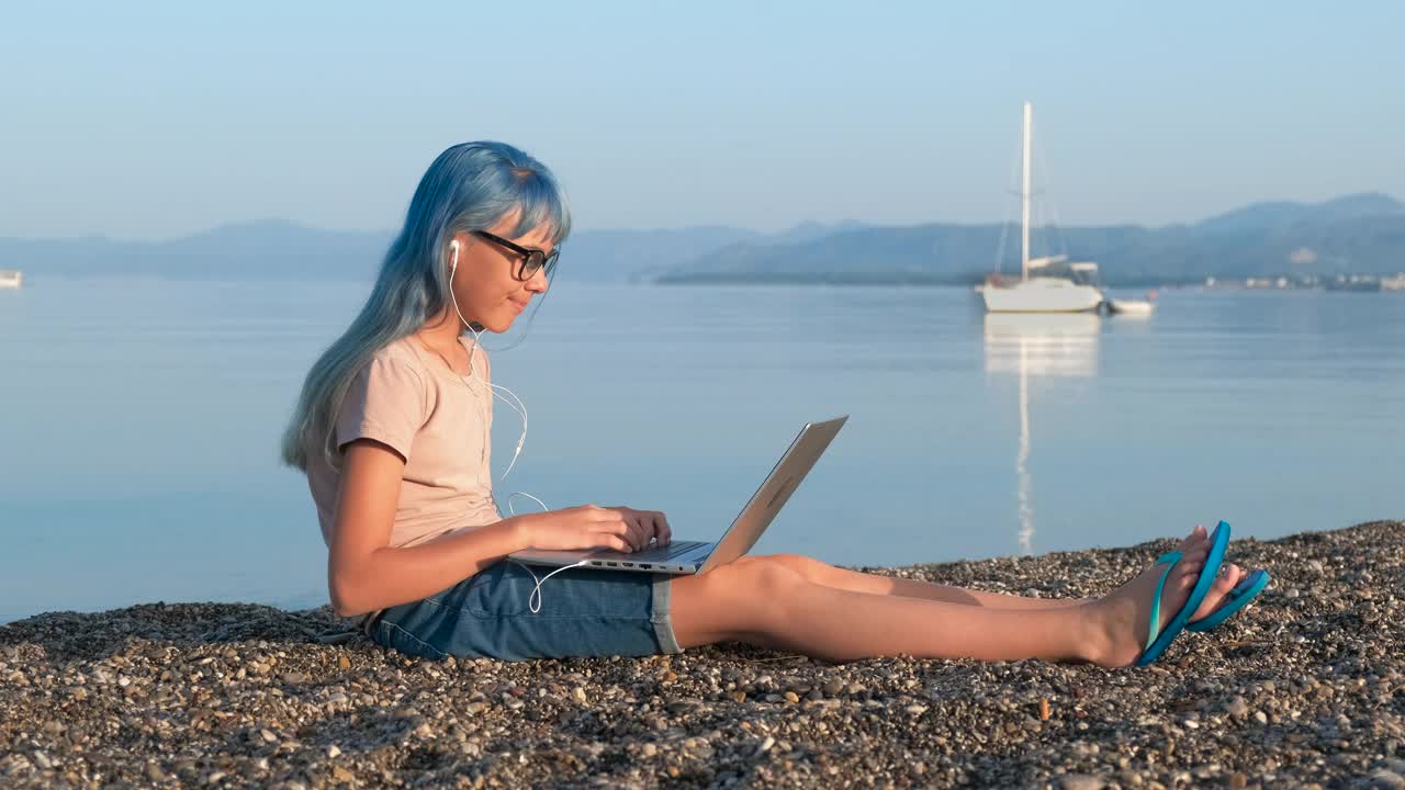 女孩在阳光海岸浏览互联网。视频素材