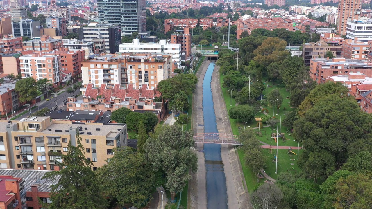 View from a drone of a park between a residential neighborhood with a water channel running through it. Bogotá. Colombia.视频素材