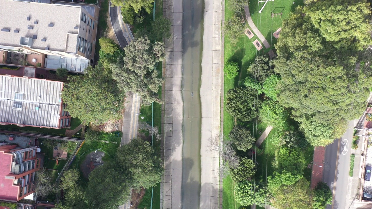 View from a drone of a park between a residential neighborhood with a water channel running through it. Bogotá. Colombia.视频下载