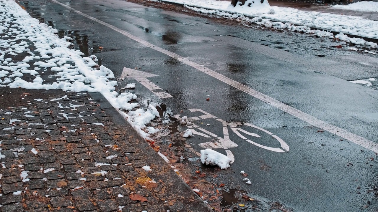 画在冬天雪覆盖的柏油路上的逆向自行车道标志视频素材