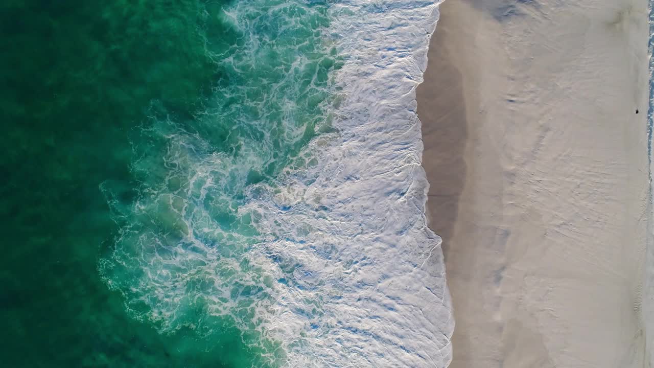 在一片僻静的白色沙滩上，漂浮在海浪之上视频素材