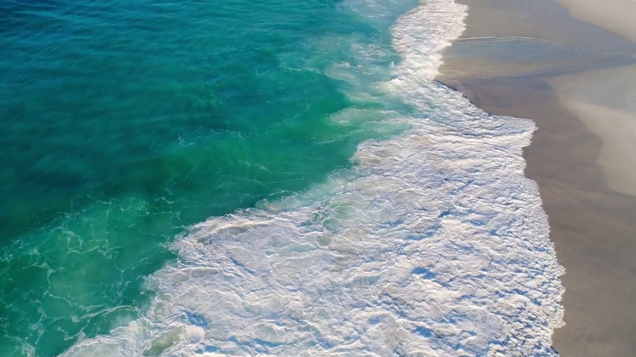 在一片僻静的白色沙滩上，漂浮在海浪之上视频素材