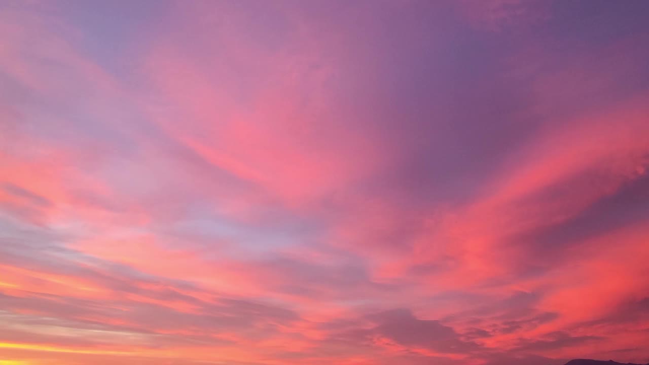 幻想清晰的粉红色天空背景和蓬松的云。天空之上，明亮的颜色梯度。抽象的天空背景与紫色和粉红色的星星。时间流逝视频素材