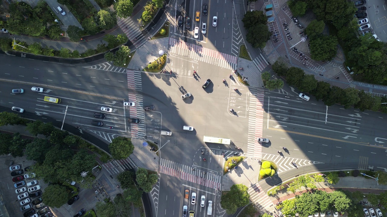 城市部分地区被阳光照亮的十字路口的交通流量鸟瞰图视频素材