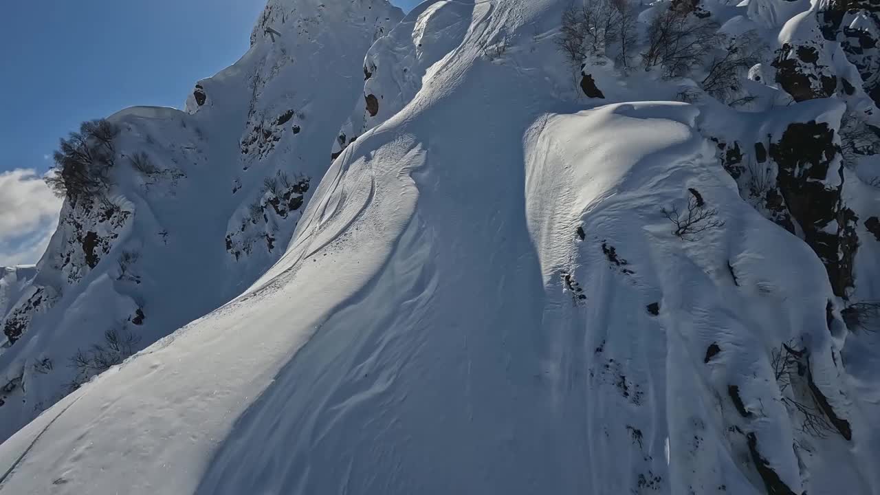 阳光明媚的雪山山脊，海拔高的山脊，人们乘坐滑雪板峰顶极限运动鸟瞰视频素材