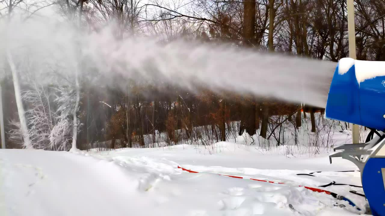 雪炮在雪道、山路附近制造人工雪粉。阳光明媚的冬日度假胜地。向下的斜坡视频下载