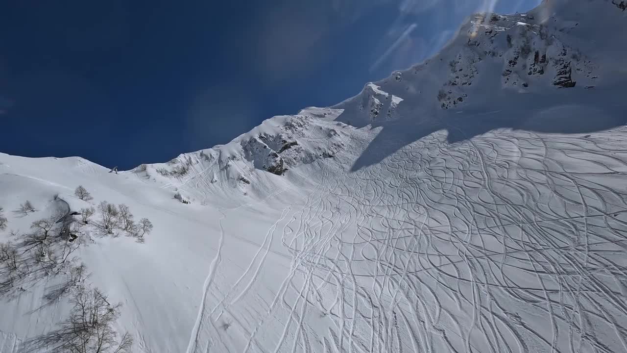 冬季高山冰冻景观蓝天阳光眩目无人机坠落到雪堆鸟瞰视频素材