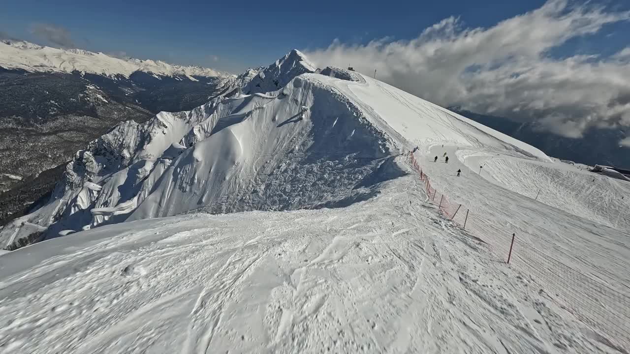 度假胜地山景如画，人们骑着滑雪板滑雪雪道活动鸟瞰视频素材