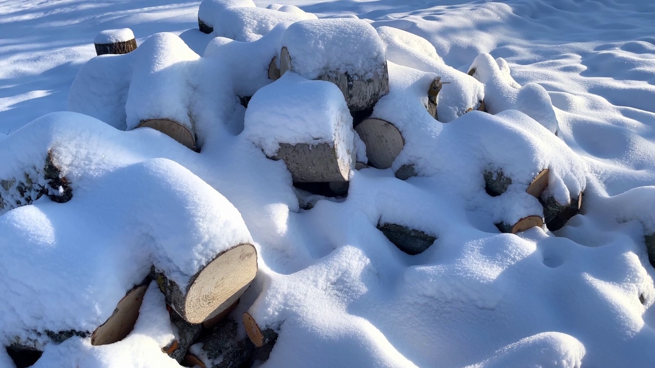 冬天的背景纹理图案与堆叠干燥的砍柴原木覆盖着雪。一堆木头被砍了。木堆上的雪。视频素材