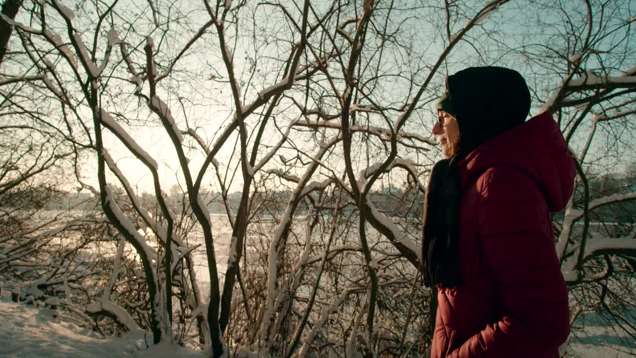 日落时分，女人走在冰雪覆盖的森林里视频素材