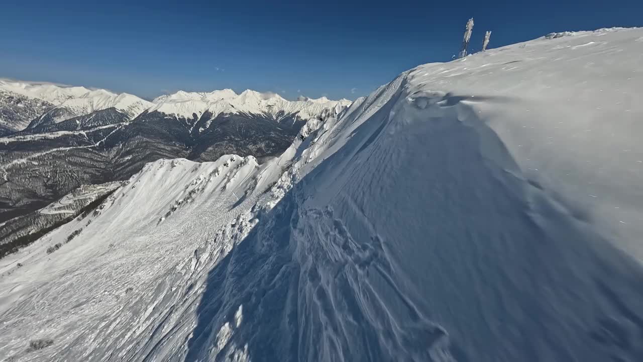 山坡滑雪道与阳光明媚的高山冬季山谷景观滑雪者在山顶鸟瞰视频素材