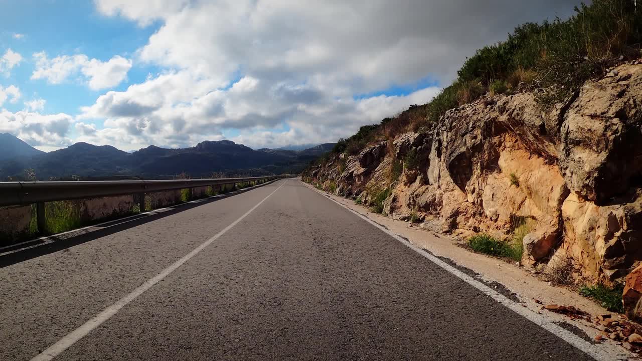 汽车行驶在空旷的山路上。在崎岖的山路上行驶视频素材