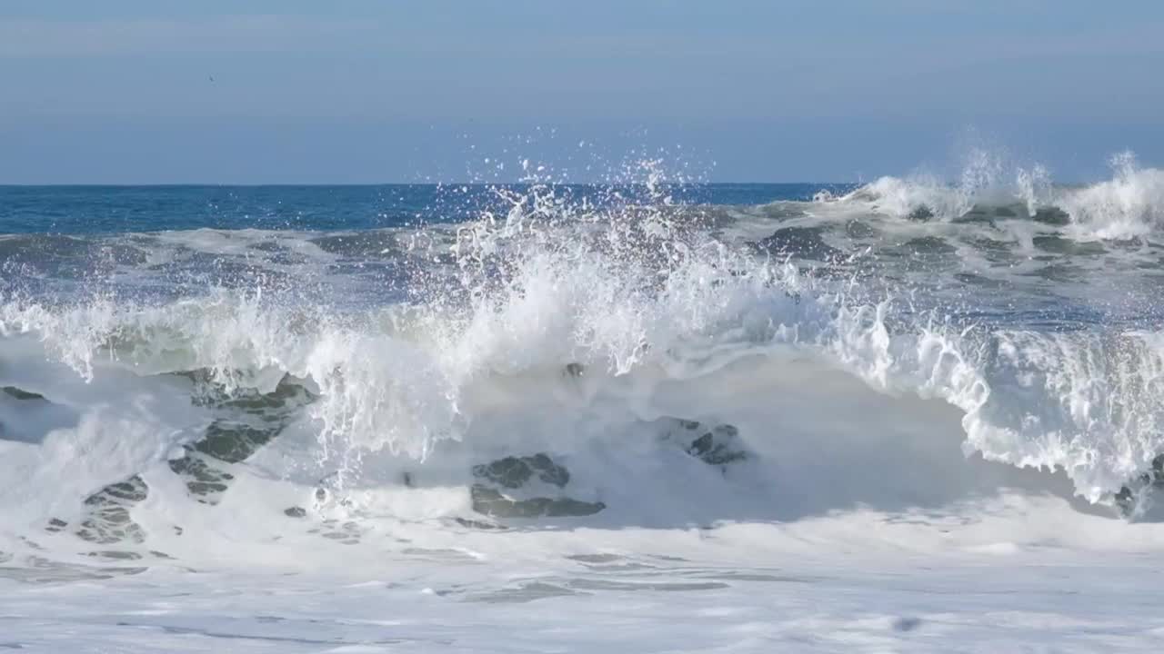 近距离观察大西洋空旷海岸上的巨浪。全高清慢动作视频，空的美丽的海洋海滩与海浪和海洋泡沫和蓝天。视频素材