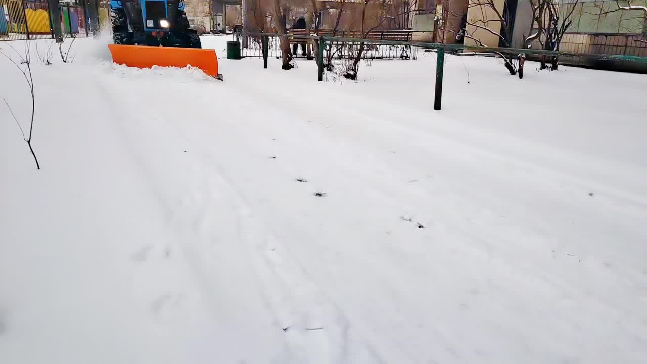 除雪车，冬季拖拉机清理城市街道上的积雪，在暴风雪，降雪后视频素材